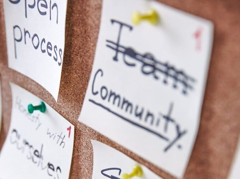 Pinned notes on a corkboard showcasing team collaboration and design skills.